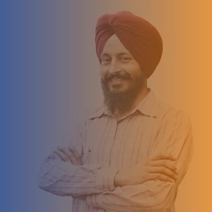Sikh man wearing a Turban, smiling with his arms folded