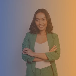 Mid 30s Asian woman in green suit stood with arms crossed