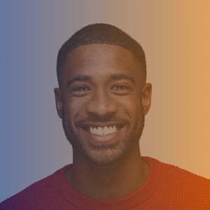 Mid 30s black man wearing a red sweater smiling