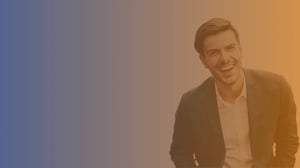 Early 30s white man leaning forward and laughing wearing white shirt and blue blazer